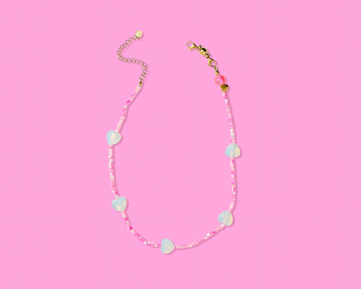 Necklace with colorful beads on a pink background